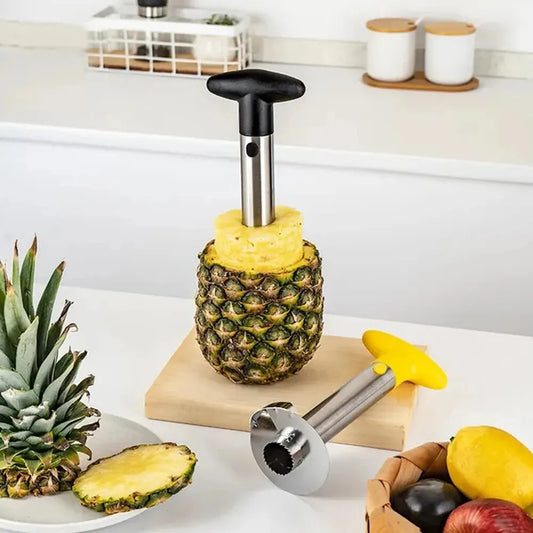 Coupe ananas en acier inoxydable utilisée pour évider et trancher un ananas entier sur un plan de travail.