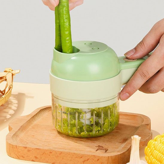 Coupe légumes électrique servant à découper des légumes verts et du maïs sur une planche