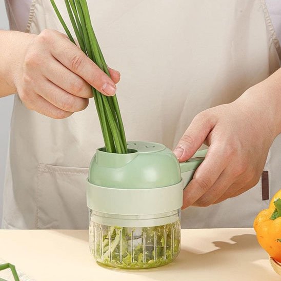 Coupe légumes électrique en action pour couper des légumes verts frais