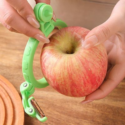 Famille utilisant un éplucheur à pommes ensemble autour d'une table, enfants et adultes souriants lors d'une préparation de tarte