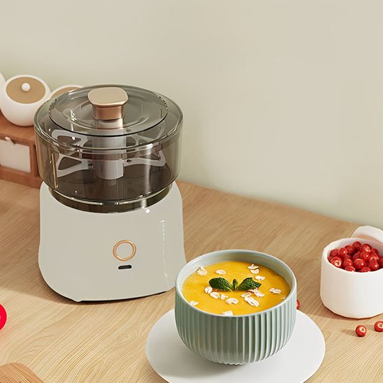 Hachoir à viande compact sur un comptoir de cuisine préparer une soupe maison décorée de menthe et amandes