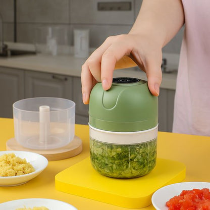 Hachoir électrique FineCut vert en utilisation avec des légumes frais hachés visibles