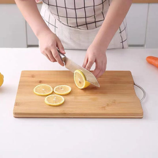 Planche à découper en bois utilisée pour trancher un citron frais dans une cuisine lumineuse