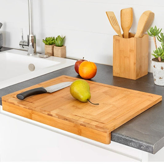 Planche à découper en bois utilisée pour trancher une poire sur un plan de travail moderne