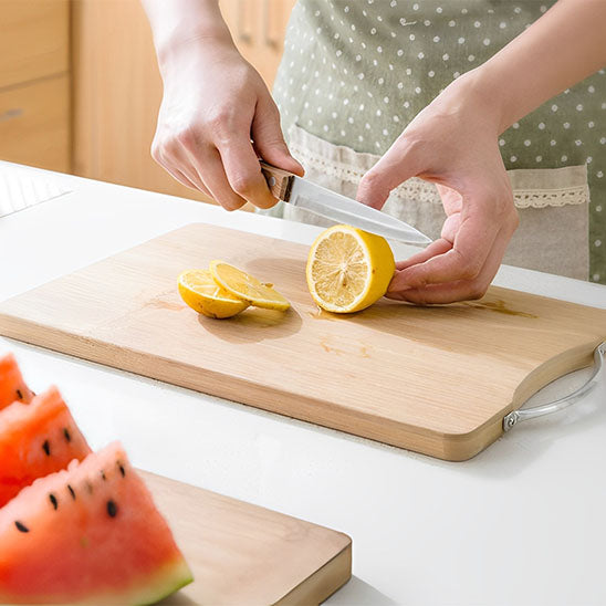 Planche à découper en bois servant à découper des fruits variés comme pastèque et citron