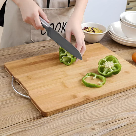 Planche à découper en bois servant à couper des légumes verts comme le poivrons