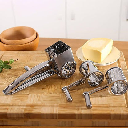 Râpe à fromage en acier inoxydable avec tambours interchangeables posée sur une surface en bois, accompagné d’accessoires de  cuisine