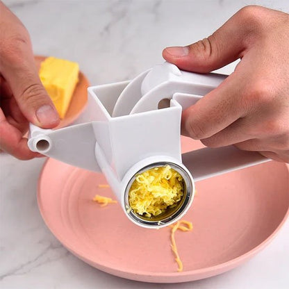 Râpe à fromage en inox utilisée pour râper du fromage jaune sur une assiette rose élégante pour une présentation raffinée