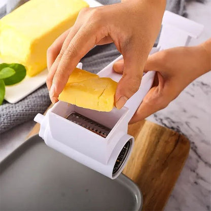 Râpe à fromage en inox manuelle servant à râper un bloc de fromage sur une planche de cuisine
